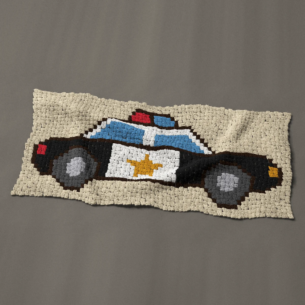 A panel worked corner to corner, 49½ by 24 inches: Police car with a red and blue light bar and gold star, 66 by 32 blocks
