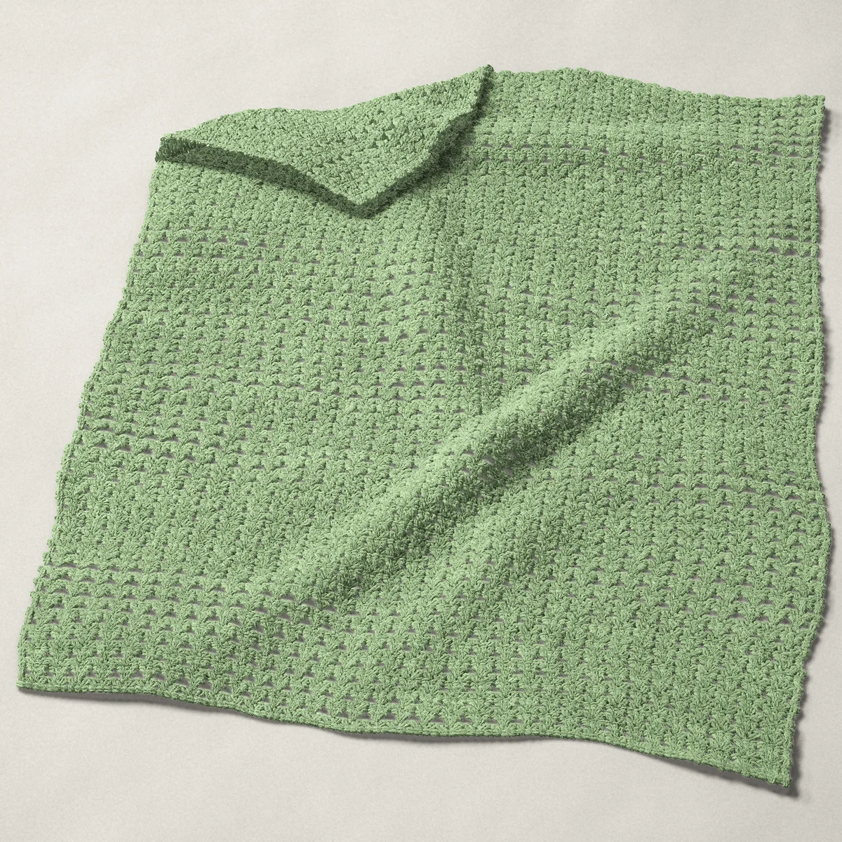 A baby blanket in primrose stitch, 32 by 40½ inches, spread out with a corner turned over