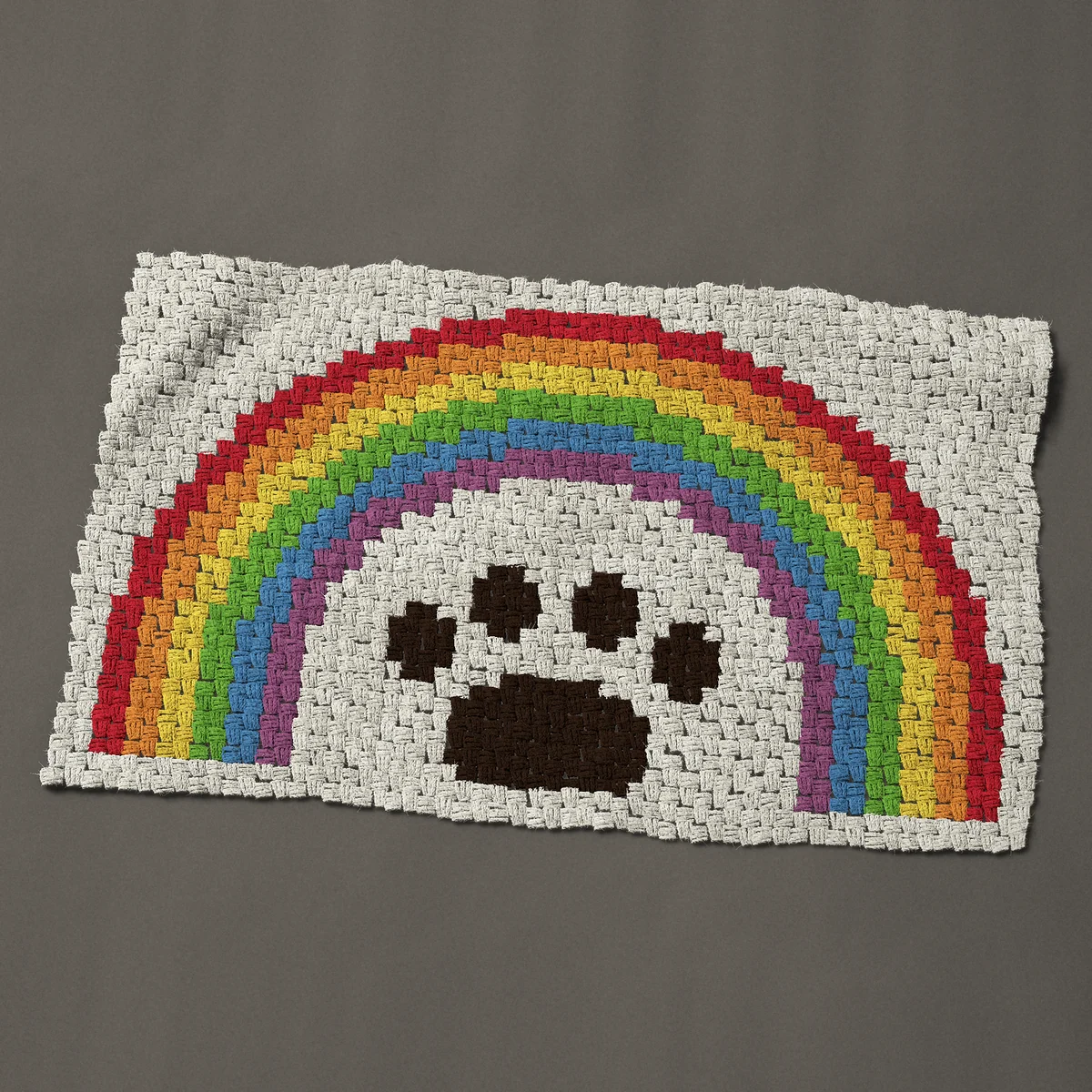 A baby blanket worked corner to corner, 43½ by 27 inches: Rainbow bridge pet memorial: paw print under a rainbow, 58 by 36 blocks