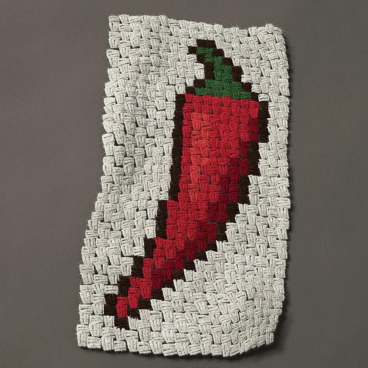 A panel worked corner to corner, 14¼ by 27 inches: Red chile pepper, a chili with a green stalk, 19 by 36 blocks