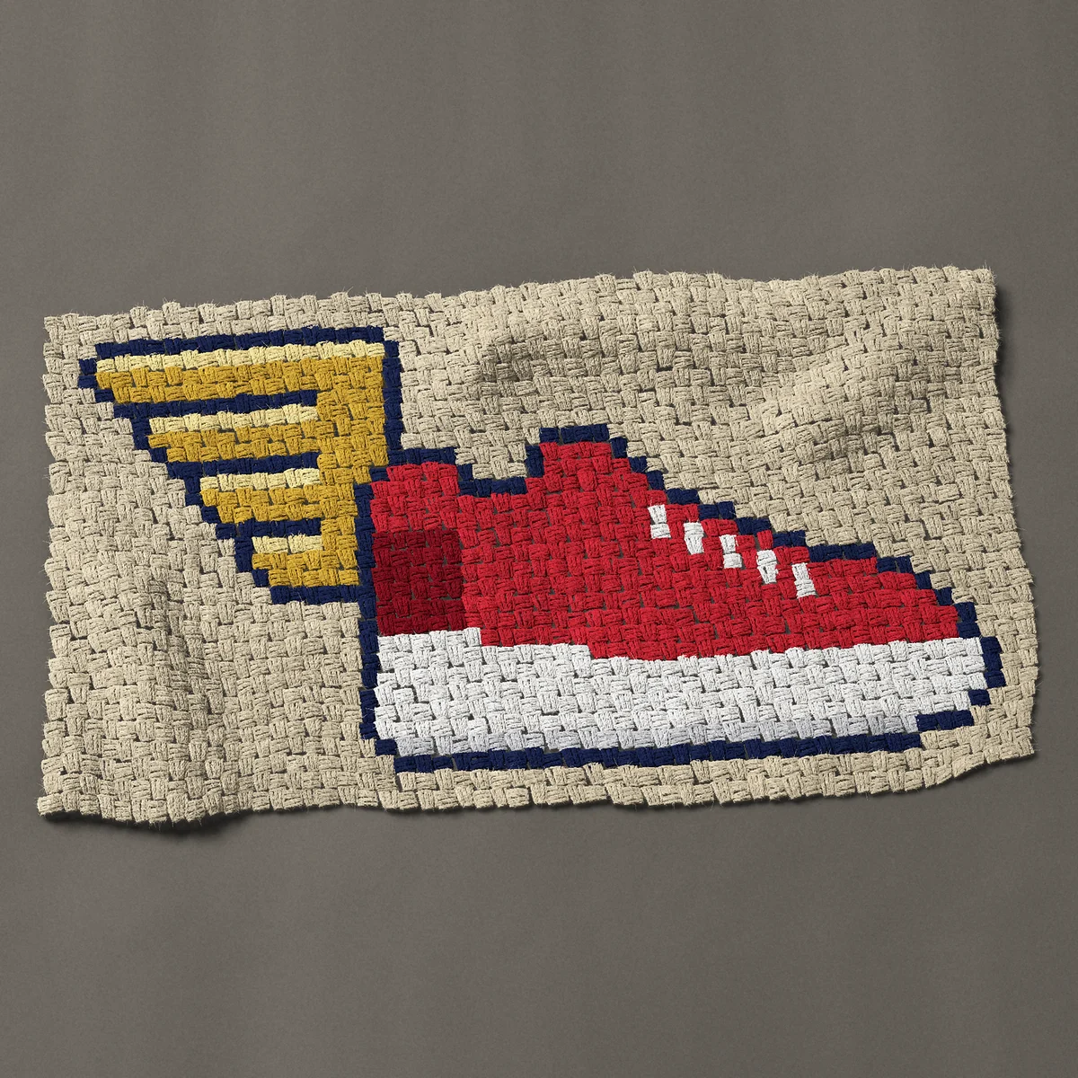 A panel worked corner to corner, 42 by 23¼ inches: Red winged running shoe for track and field runners, 56 by 31 blocks