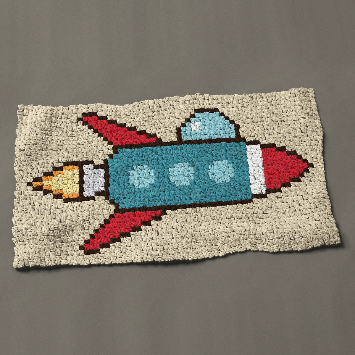 A baby blanket worked corner to corner, 45½ by 26¼ inches: Retro rocket ship spaceship with a bubble canopy, 61 by 35 blocks