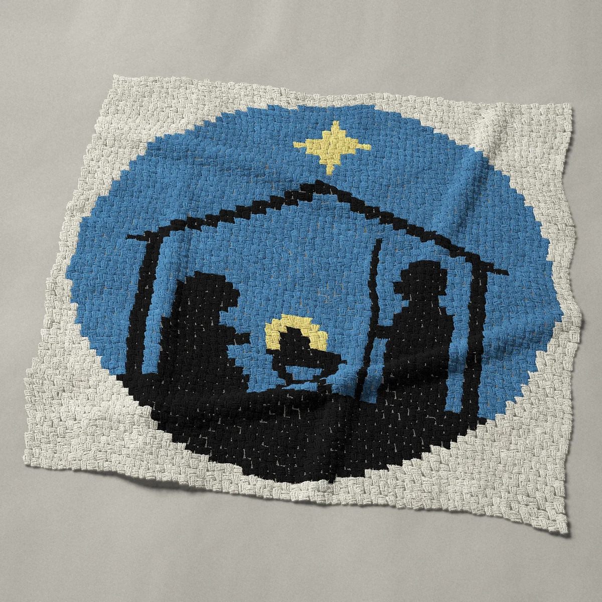 A throw worked corner to corner, 50 by 50 inches: Nativity silhouette, round with stable and star, 67 by 67 blocks