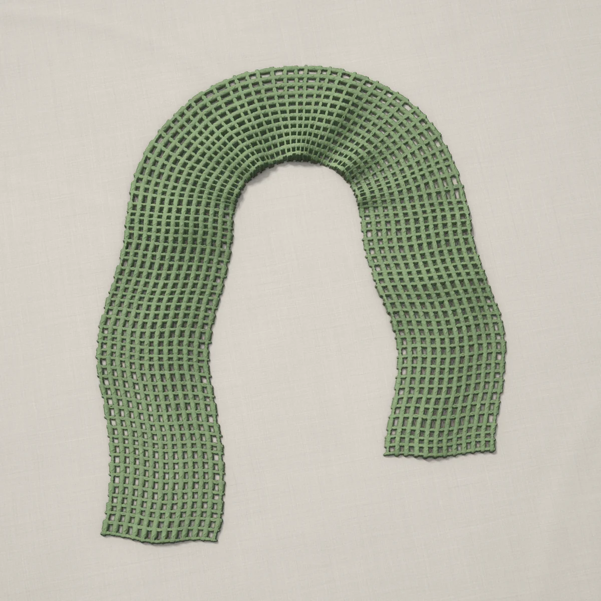 A scarf in double crochet mesh, 7 by 60 inches, lying in a loose bend