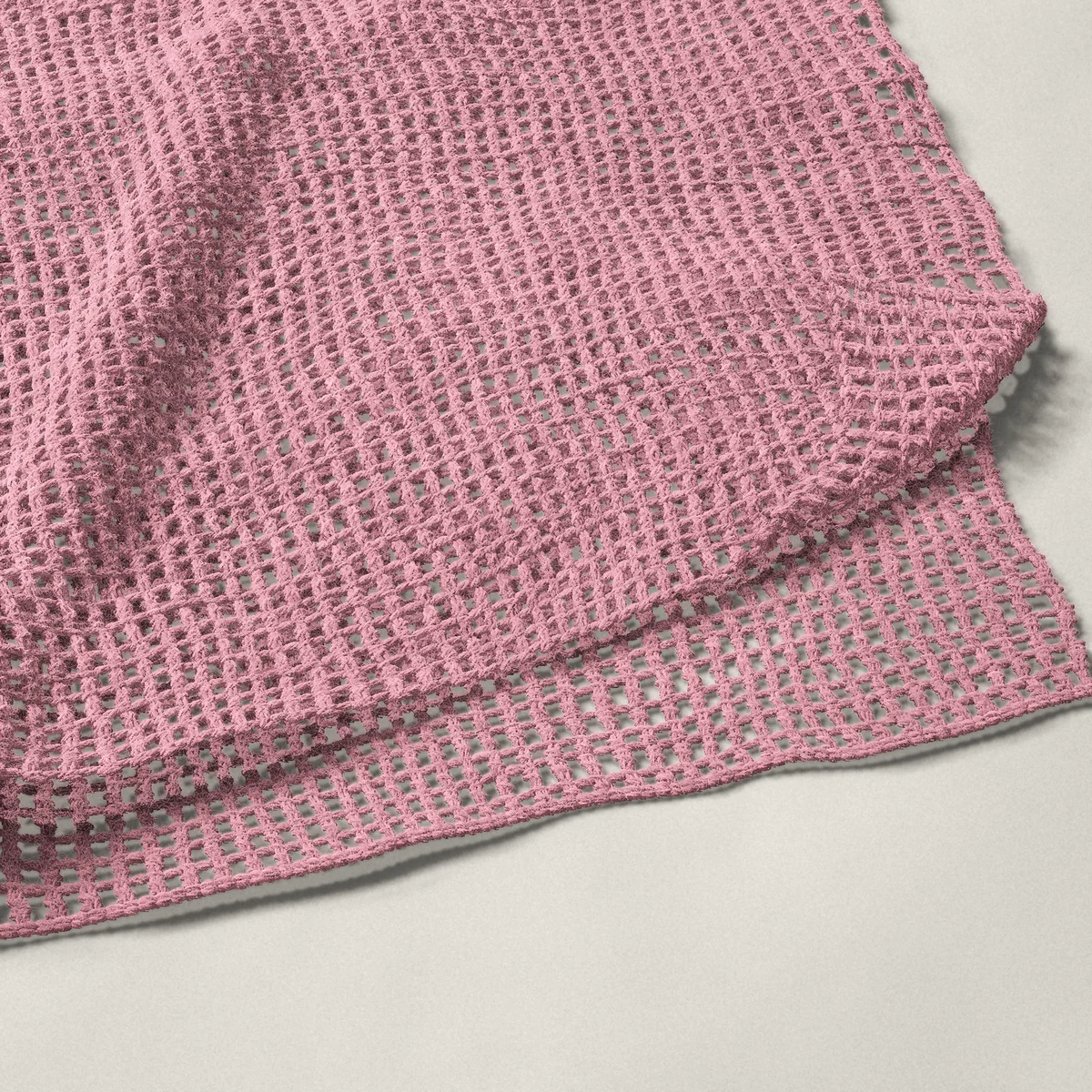 A throw in double crochet mesh, 50¼ by 60 inches, folded in half with a corner turned back