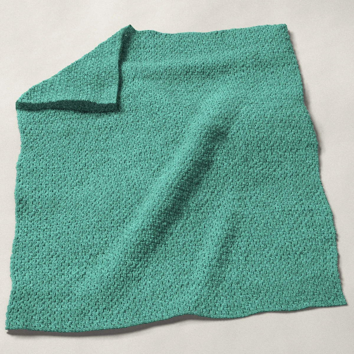 A baby blanket in single and double crochet pairs, 32¼ by 40 inches, spread out with a corner turned over