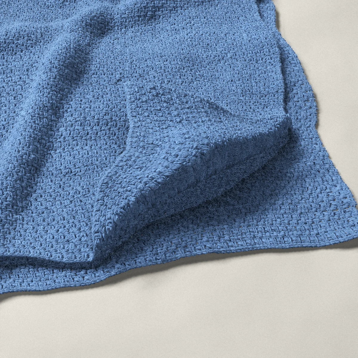 A throw in single and double crochet pairs, 50¼ by 60 inches, folded in half with a corner turned back