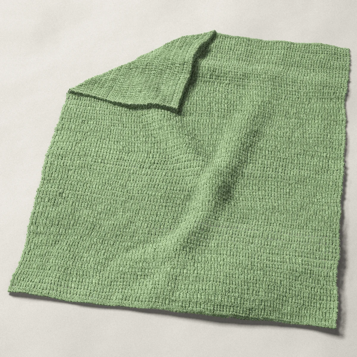 A baby blanket in single and double crochet rows, 32 by 40 inches, spread out with a corner turned over