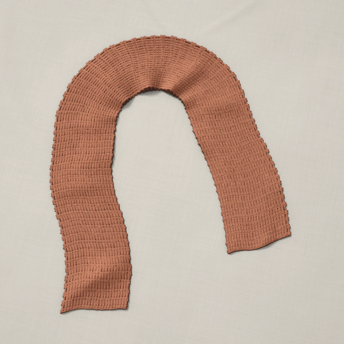 A scarf in single and double crochet rows, 7.1 by 60.2 inches, lying in a loose bend