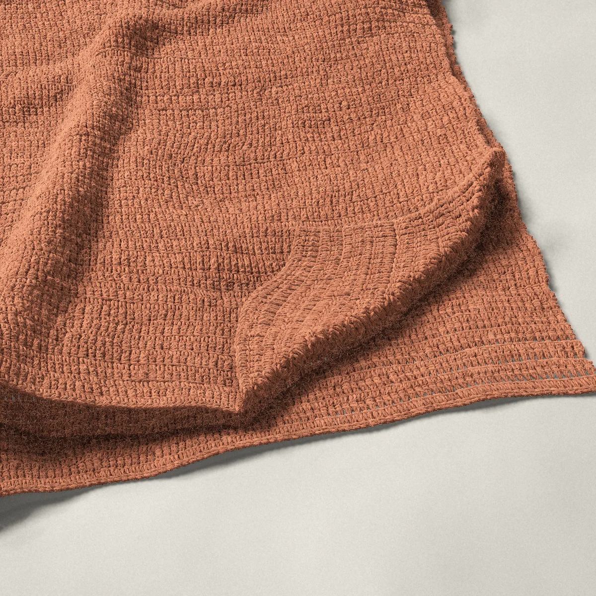 A throw in single and double crochet rows, 50¼ by 60¼ inches, folded in half with a corner turned back