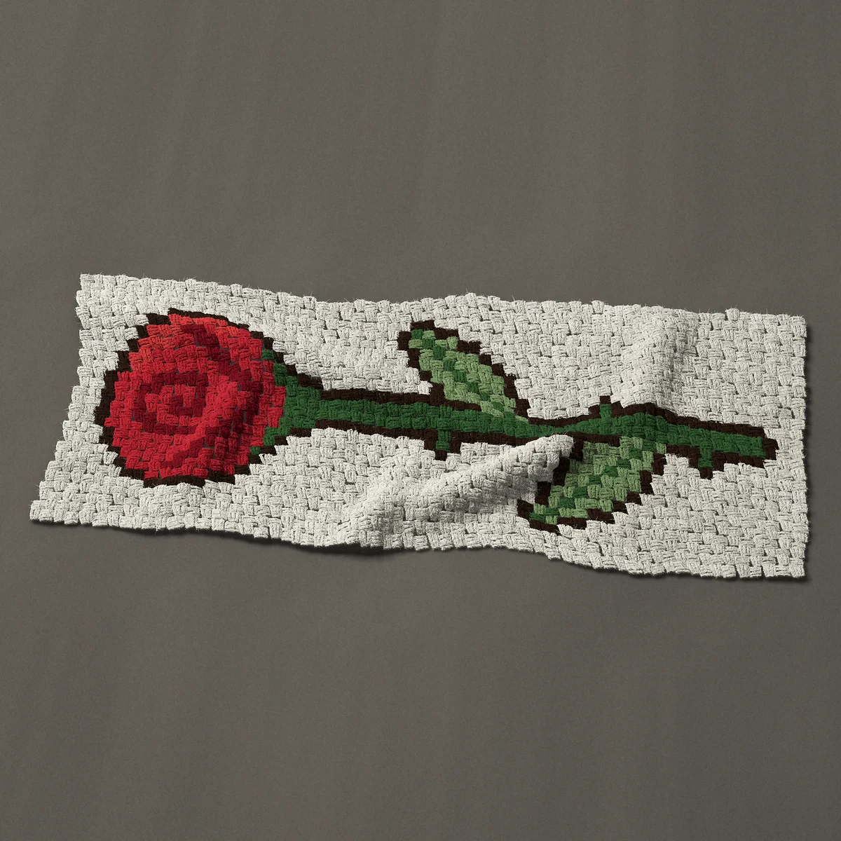 A panel worked corner to corner, 45½ by 19½ inches: Single long-stemmed red rose lying on its side, 61 by 26 blocks