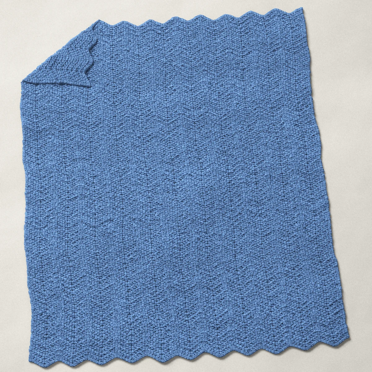 A baby blanket in single crochet ripple, 31½ by 40 inches, spread out with a corner turned over