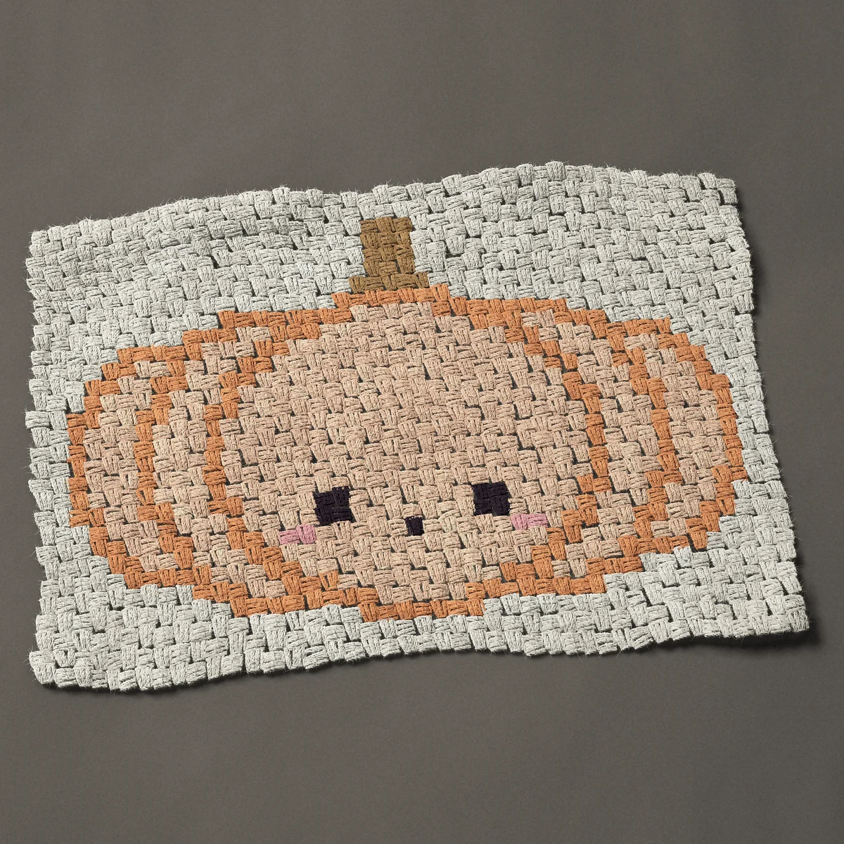 A panel worked corner to corner, 32¼ by 22½ inches: Kawaii pumpkin with a face and pink cheeks, 43 by 30 blocks