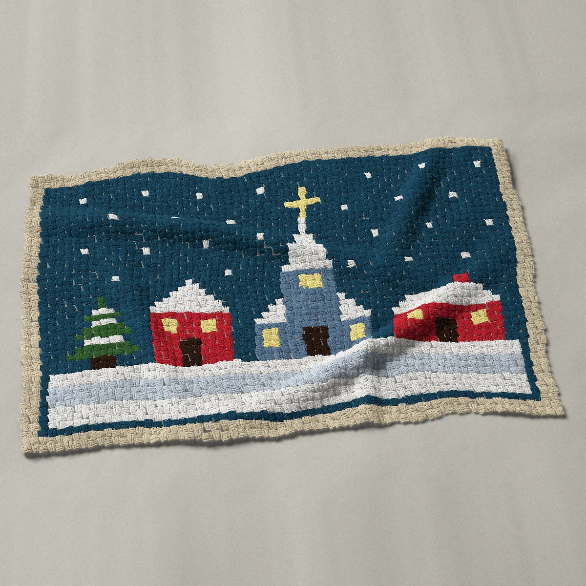 A baby blanket worked corner to corner, 51 by 34½ inches: Snowy winter village at dusk with a church, lit windows, 68 by 46 blocks