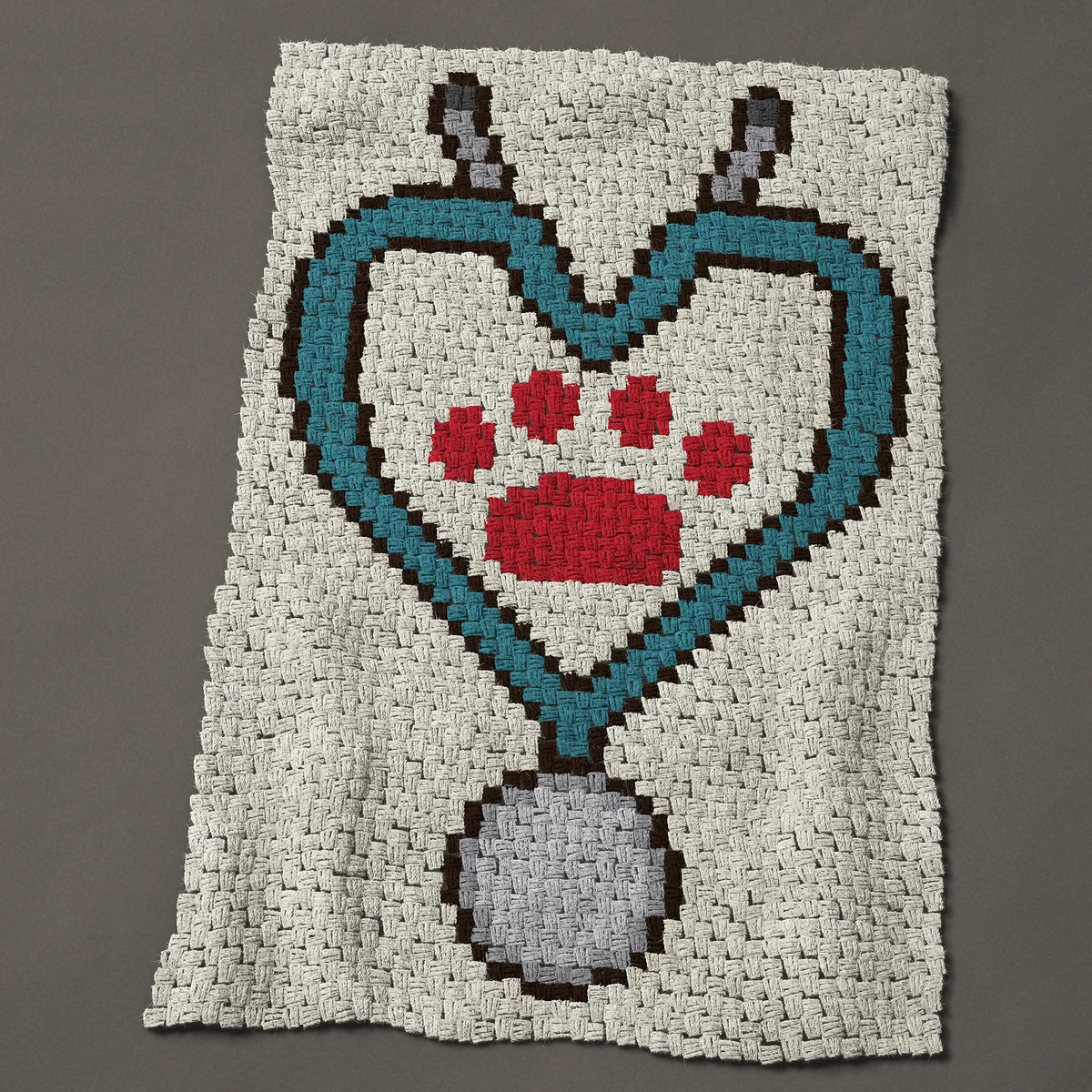 A baby blanket worked corner to corner, 33 by 48½ inches: Veterinarian stethoscope heart with a red paw print, 44 by 65 blocks
