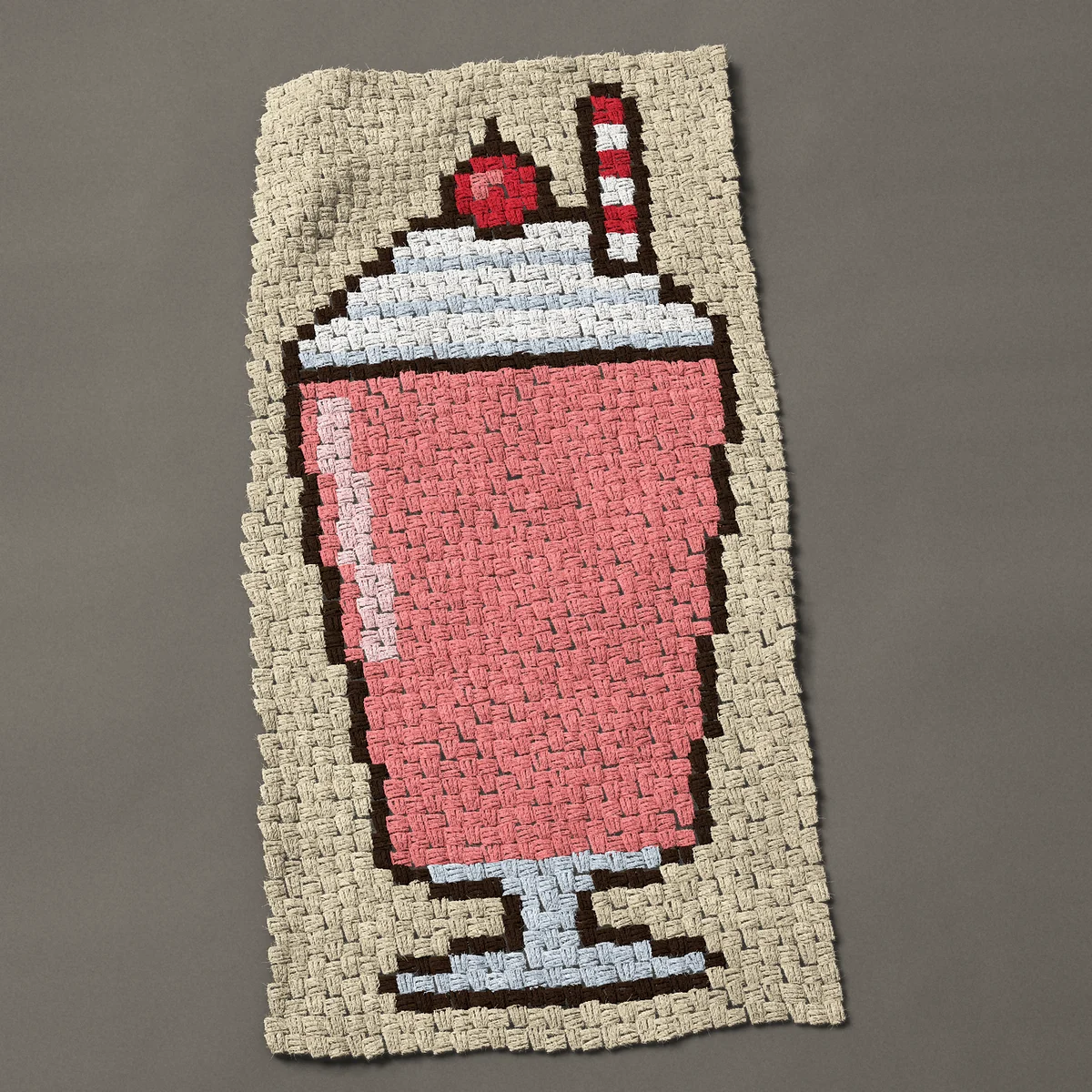 A panel worked corner to corner, 23¼ by 46½ inches: Strawberry milkshake with whipped cream and a cherry, 31 by 62 blocks
