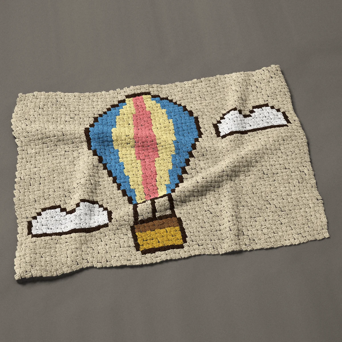 A lap blanket worked corner to corner, 49½ by 37½ inches: Striped hot air balloon between two white clouds, 66 by 50 blocks