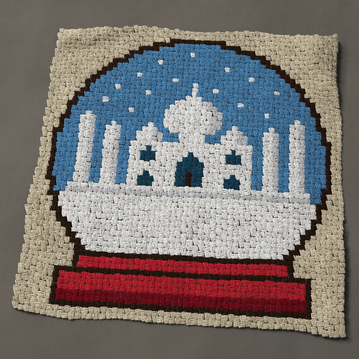 A panel worked corner to corner, 42½ by 44 inches: Taj Mahal snow globe with falling snow on a red stand, 57 by 59 blocks