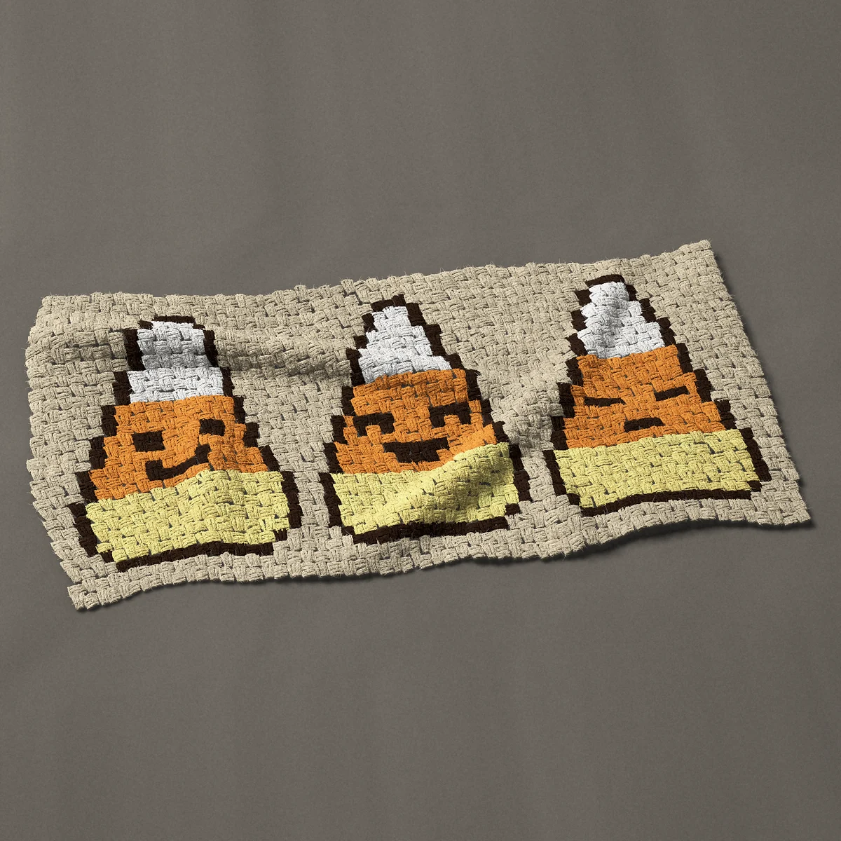 A panel worked corner to corner, 44 by 21¾ inches: Three candy corn with cute faces, 59 by 29 blocks