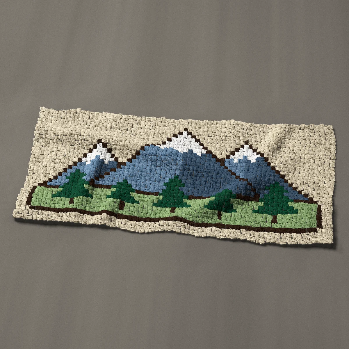 A panel worked corner to corner, 50 by 23¼ inches: Three snowy mountain peaks with a row of pine trees, 67 by 31 blocks