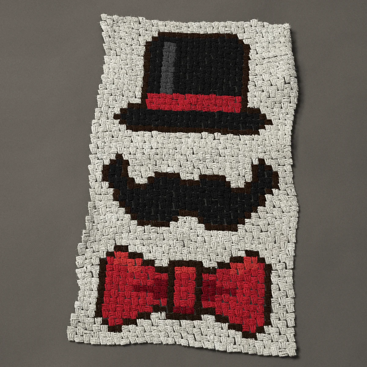 A panel worked corner to corner, 23¼ by 41 inches: Top hat, moustache and red bow tie, 31 by 55 blocks