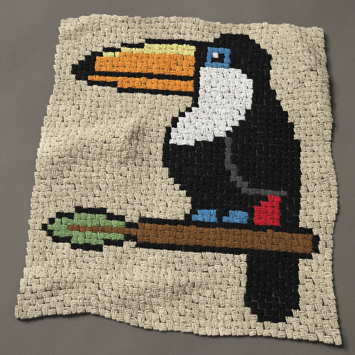 A baby blanket worked corner to corner, 35¼ by 40½ inches: Toucan perched on a branch with a green leaf, 47 by 54 blocks