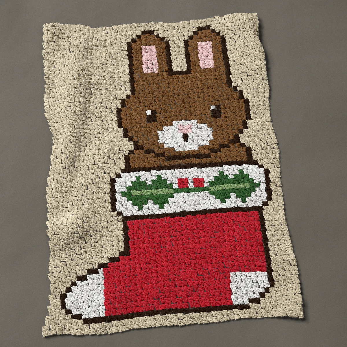 A baby blanket worked corner to corner, 33¾ by 50 inches: Christmas rabbit in a red stocking with a holly sprig, 45 by 67 blocks