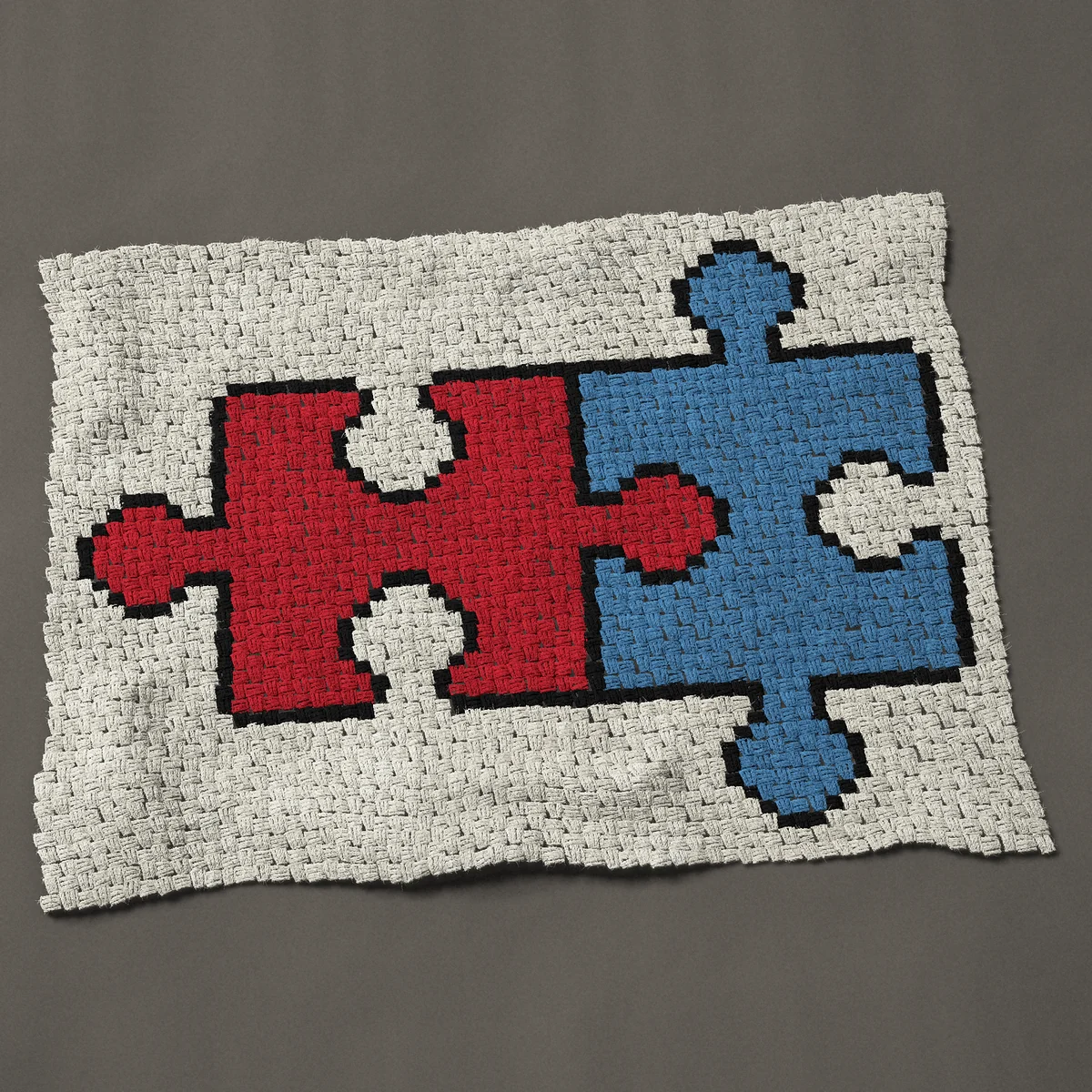 A lap blanket worked corner to corner, 46½ by 35¼ inches: Two interlocking jigsaw puzzle pieces, red and blue, 62 by 47 blocks