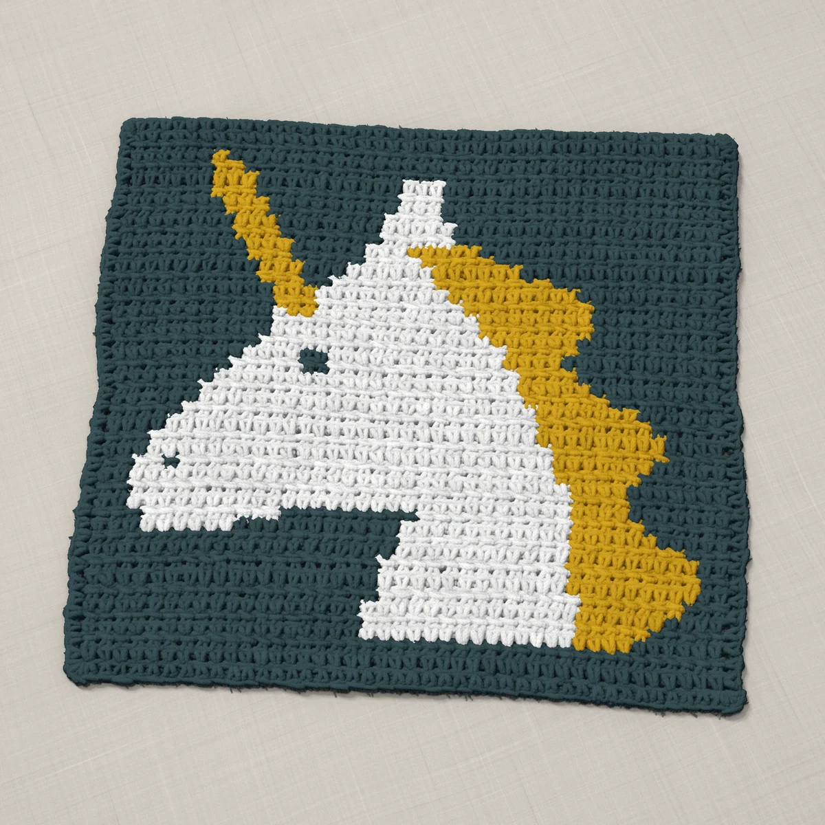 A pillow front in single crochet, 12.9 by 12 inches: a unicorn's head in white and gold on a slate gray ground, 42 stitches by 45 rows
