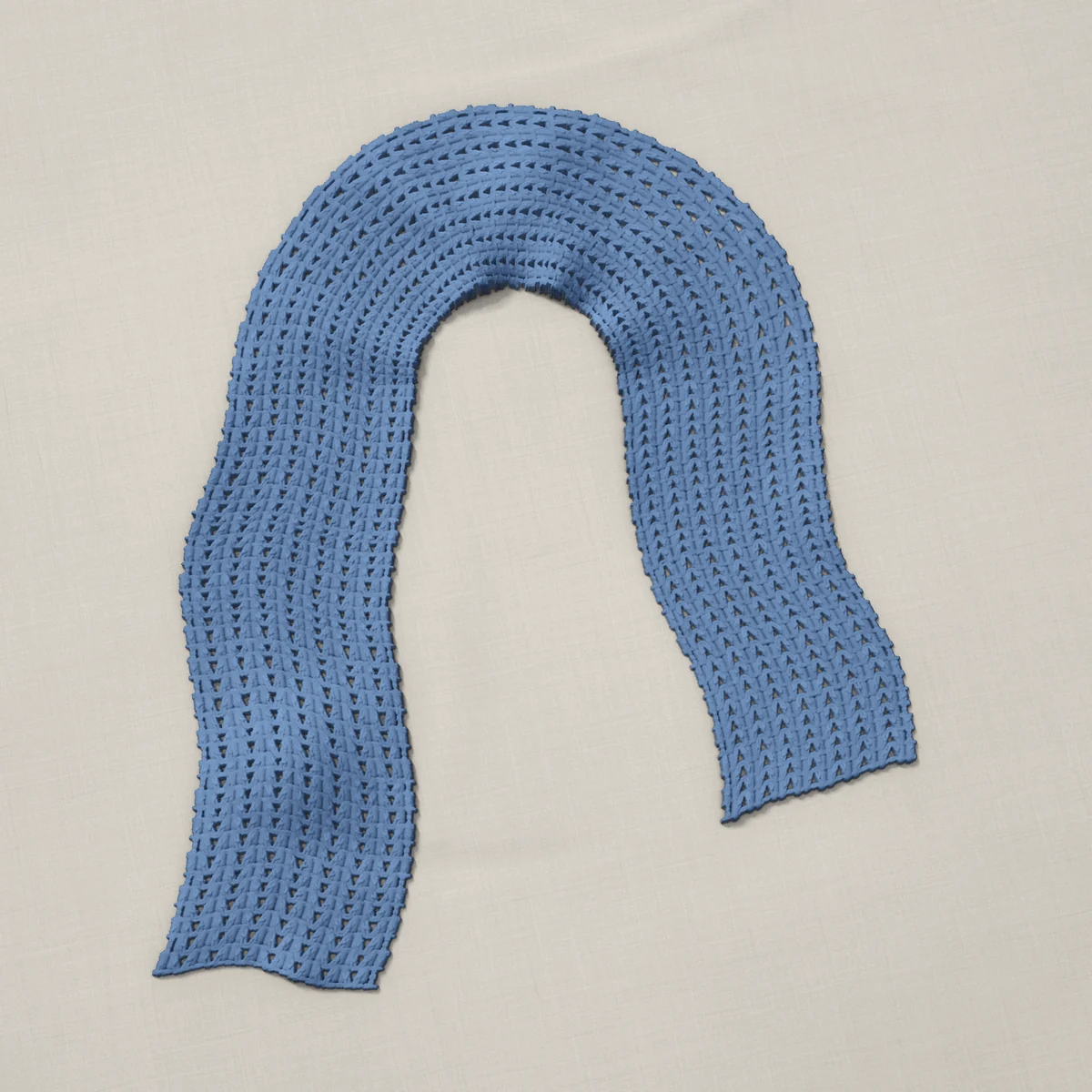 A scarf in V-stitch, 7.1 by 60.3 inches, lying in a loose bend