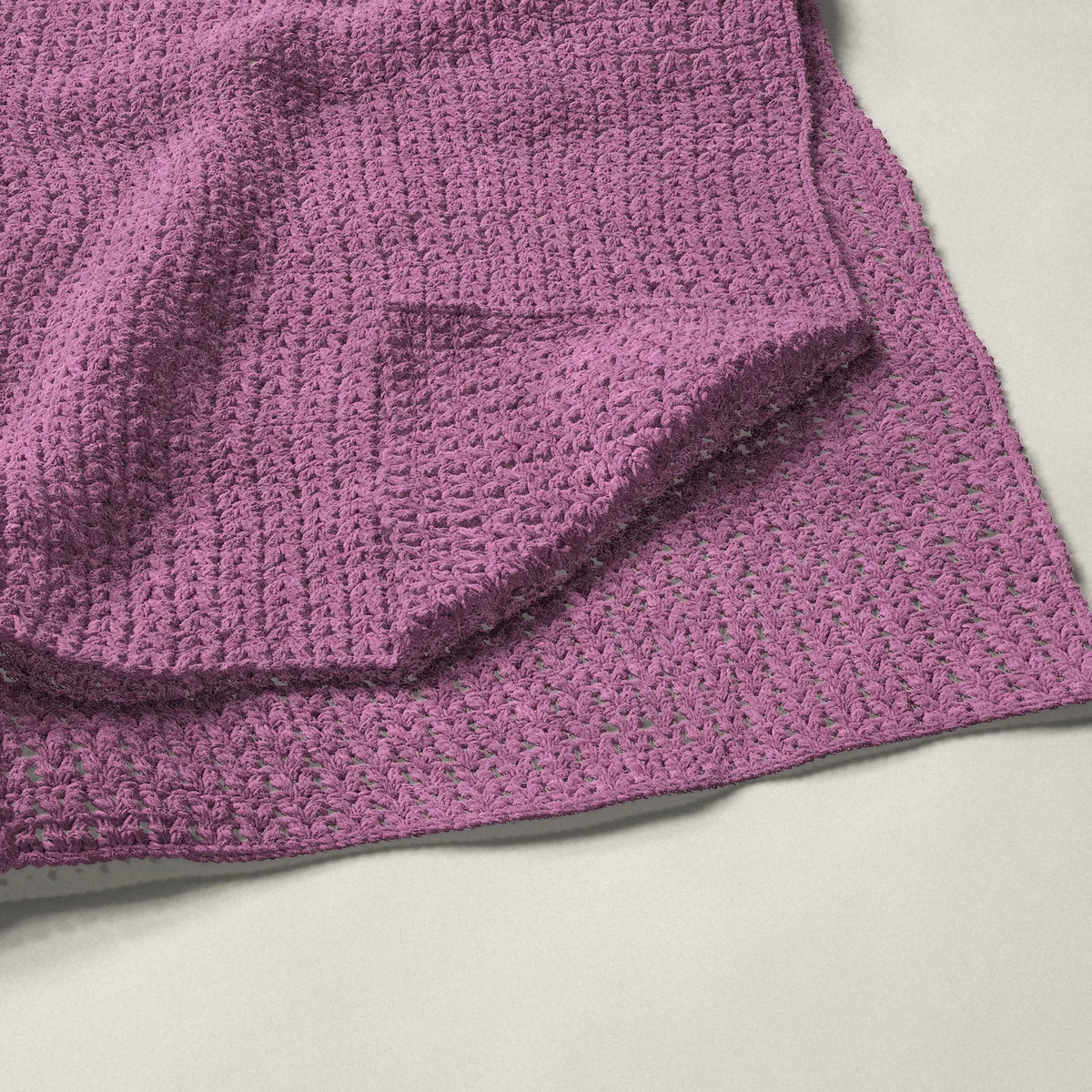 A throw in V-stitch, 50½ by 60¼ inches, folded in half with a corner turned back
