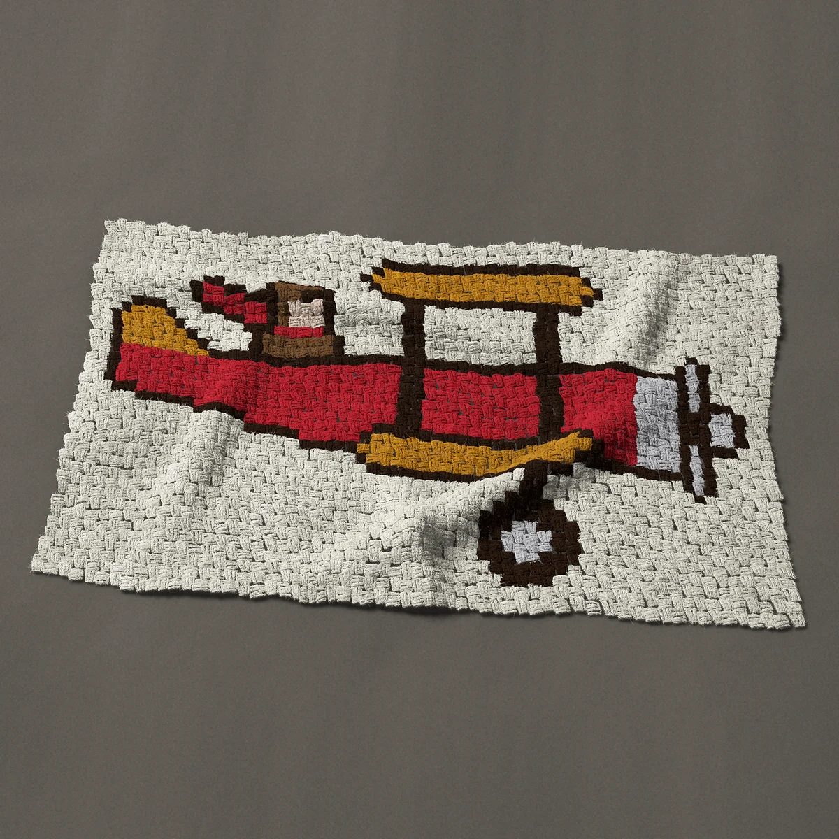 A baby blanket worked corner to corner, 45½ by 28½ inches: Vintage red biplane with a pilot and flying scarf, 61 by 38 blocks