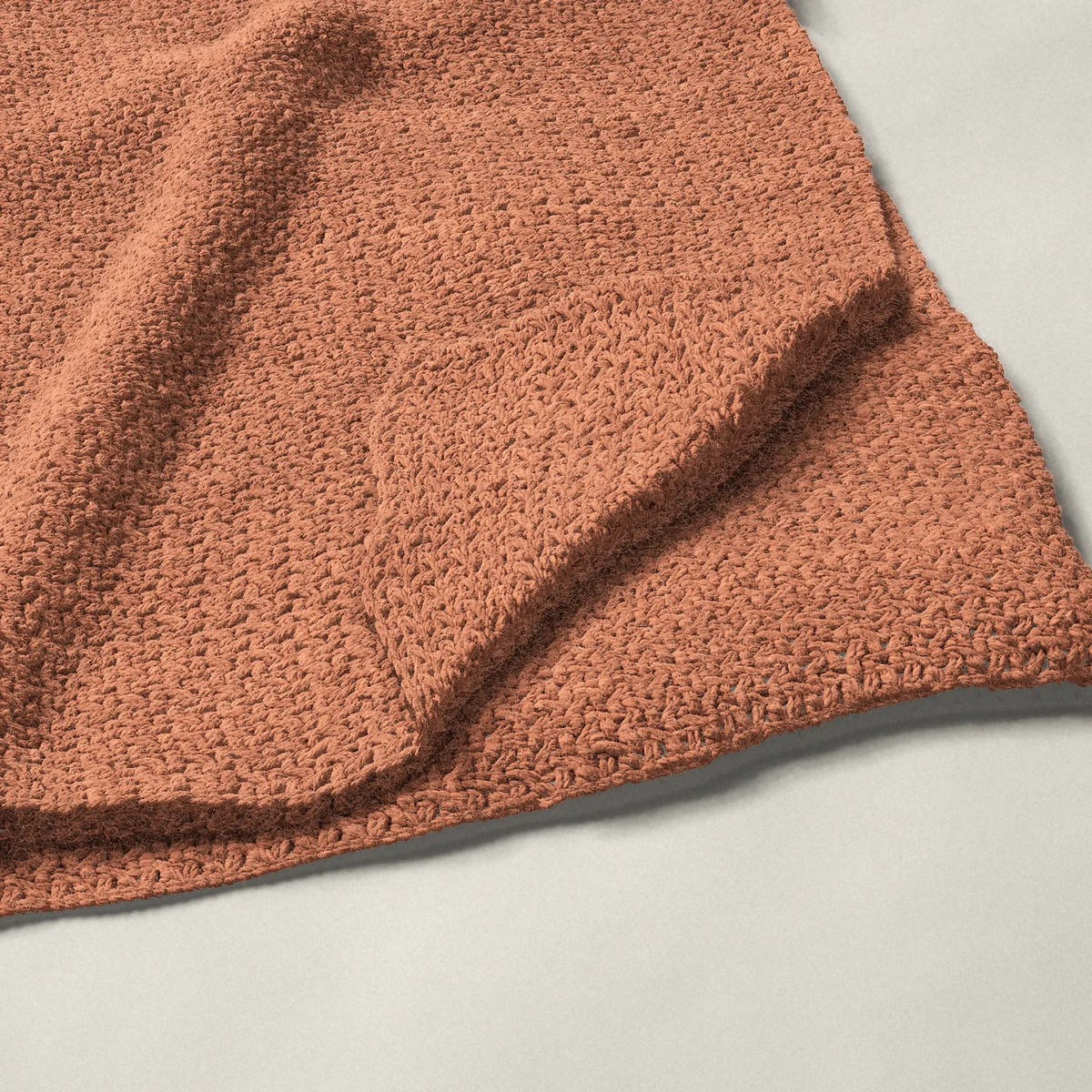 A throw in wattle stitch, 50¼ by 60¼ inches, folded in half with a corner turned back