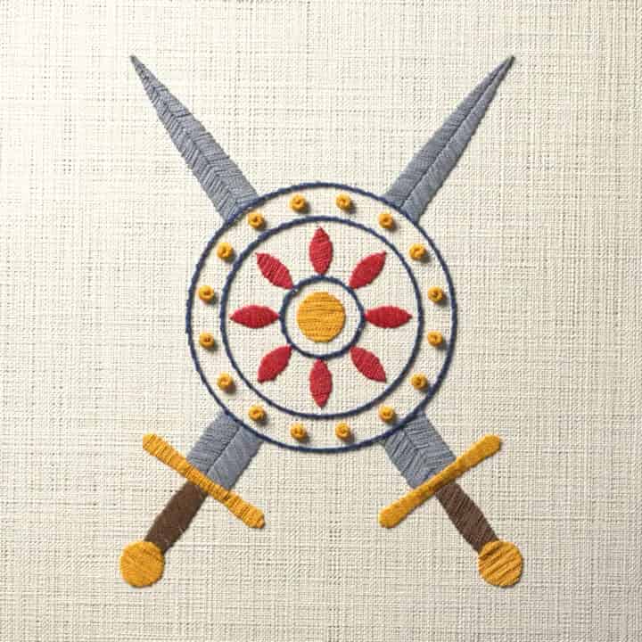 Crossed swords behind a round shield: preview of the stitched design
