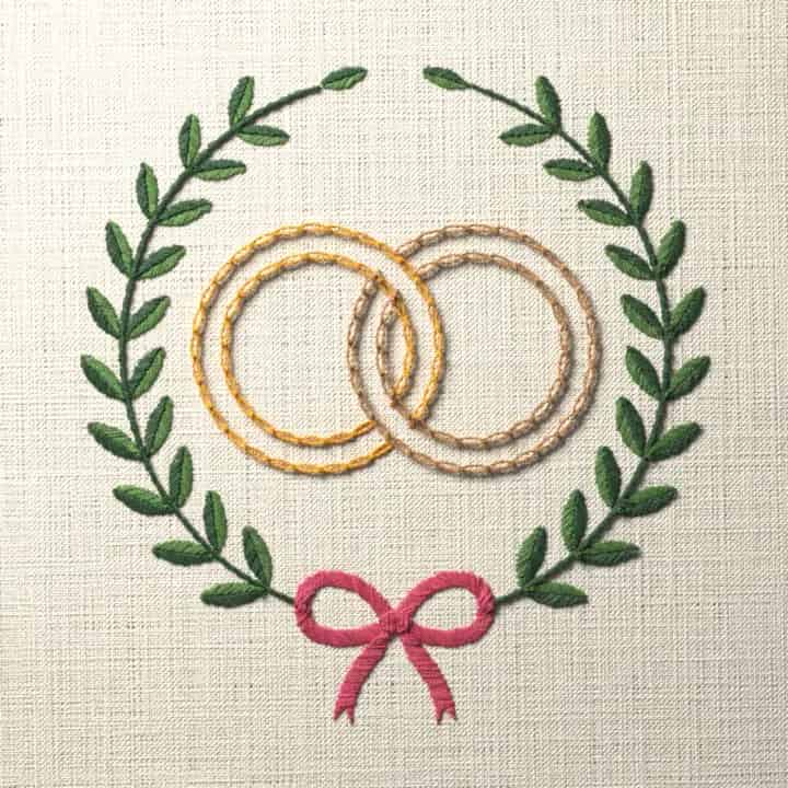 Wedding rings in a laurel wreath: preview of the stitched design